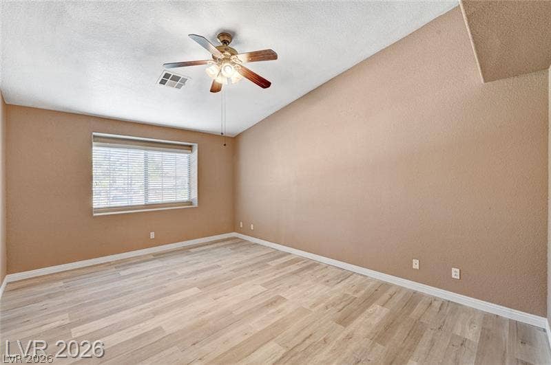 3327 Erva Street, #207, Las Vegas, NV 89117 A spacious bedroom showcases handsome wood-look flooring and a high vaulted ceiling line.
