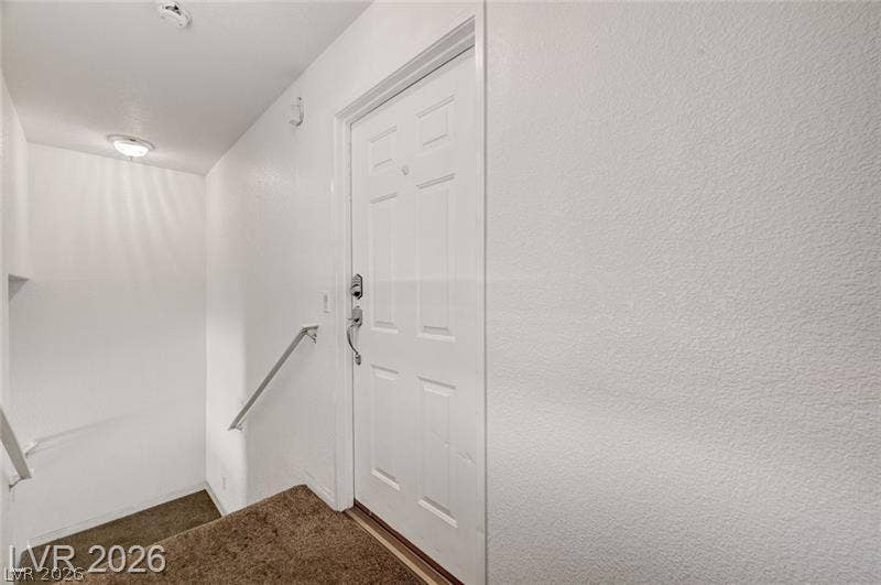 3327 Erva Street, #207, Las Vegas, NV 89117 Plush carpeting and crisp white walls create an inviting entrance near the stairway landing.