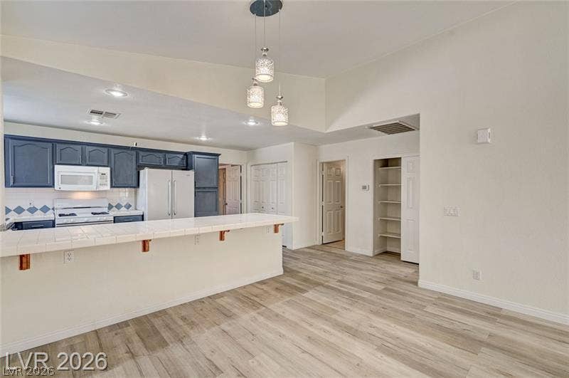 3327 Erva Street, #207, Las Vegas, NV 89117 Gleaming wood-look floors anchor this airy space, transitioning seamlessly from cooking to casual living.