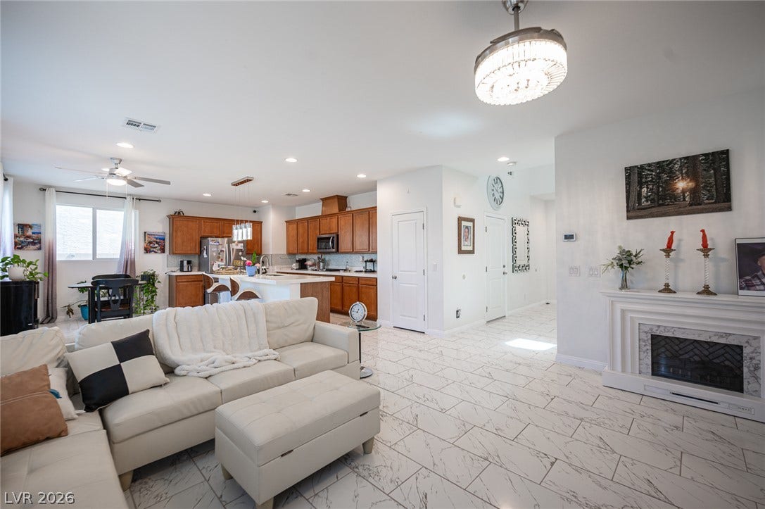 An open layout connects the living spaces over polished marble-patterned tile floors.