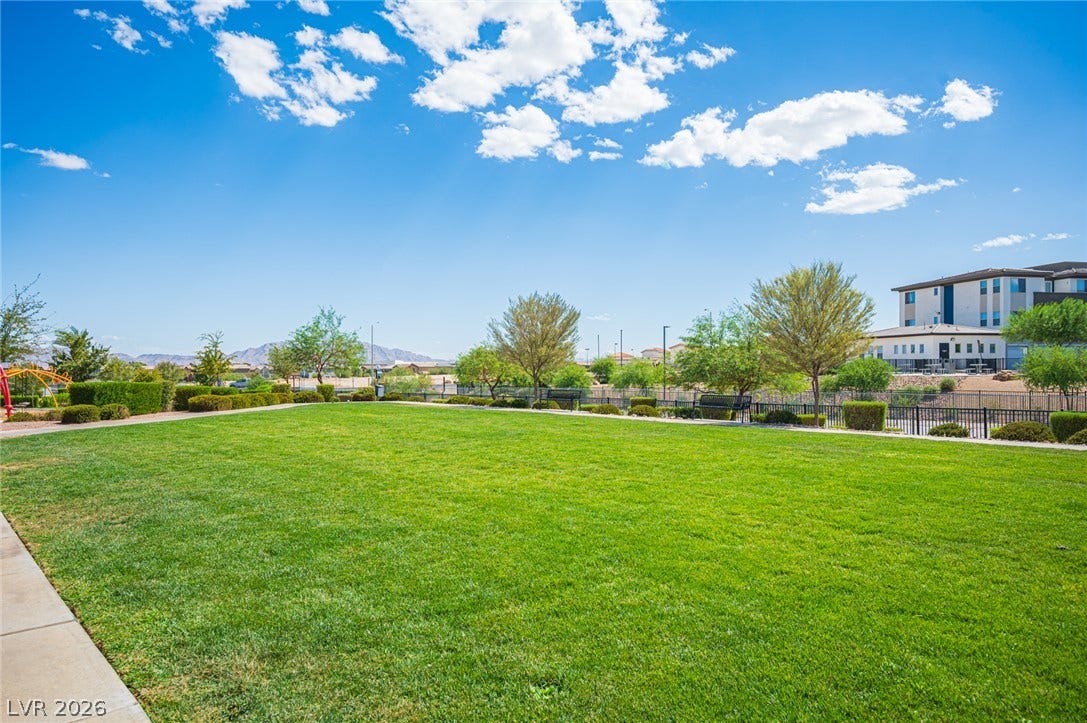 A manicured community park area under a blue sky offers space for outdoor relaxation.