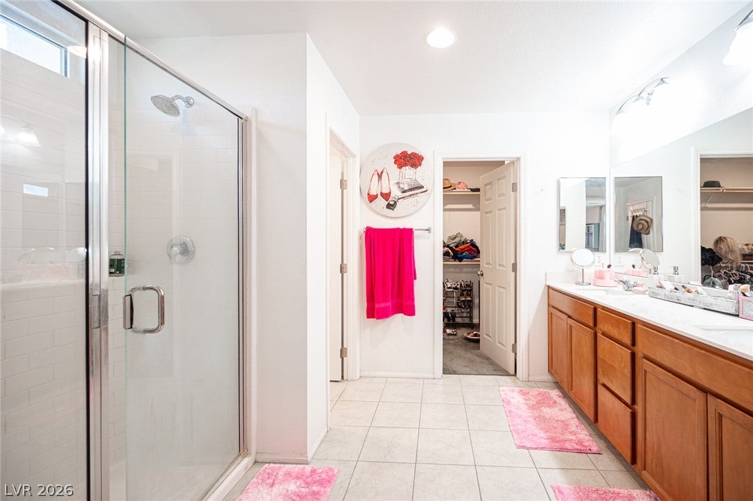 Clean tile flooring and a glass-enclosed shower define this spacious bathroom layout.
