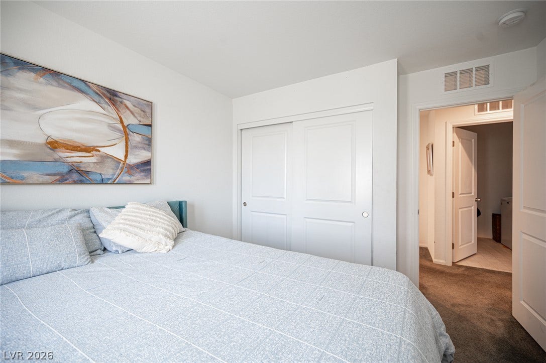Plush carpeted flooring runs through this serene bedroom featuring a wide closet.
