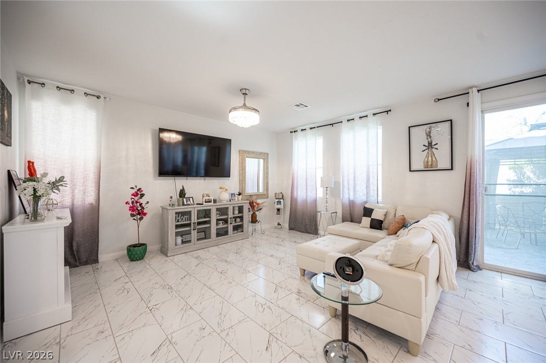 Gleaming tile floors and natural light from sliding glass doors define this inviting living area.
