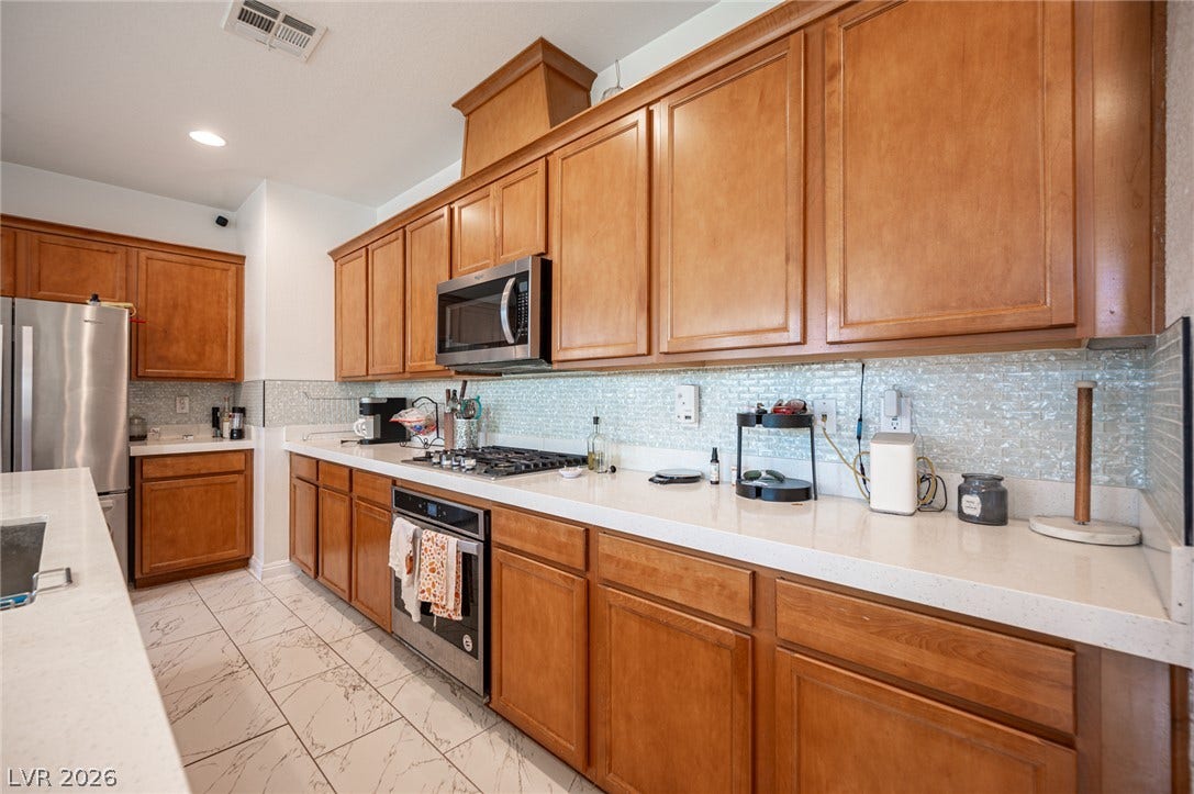 Gleaming tile flooring and warm wood cabinetry define this beautifully appointed cooking space.