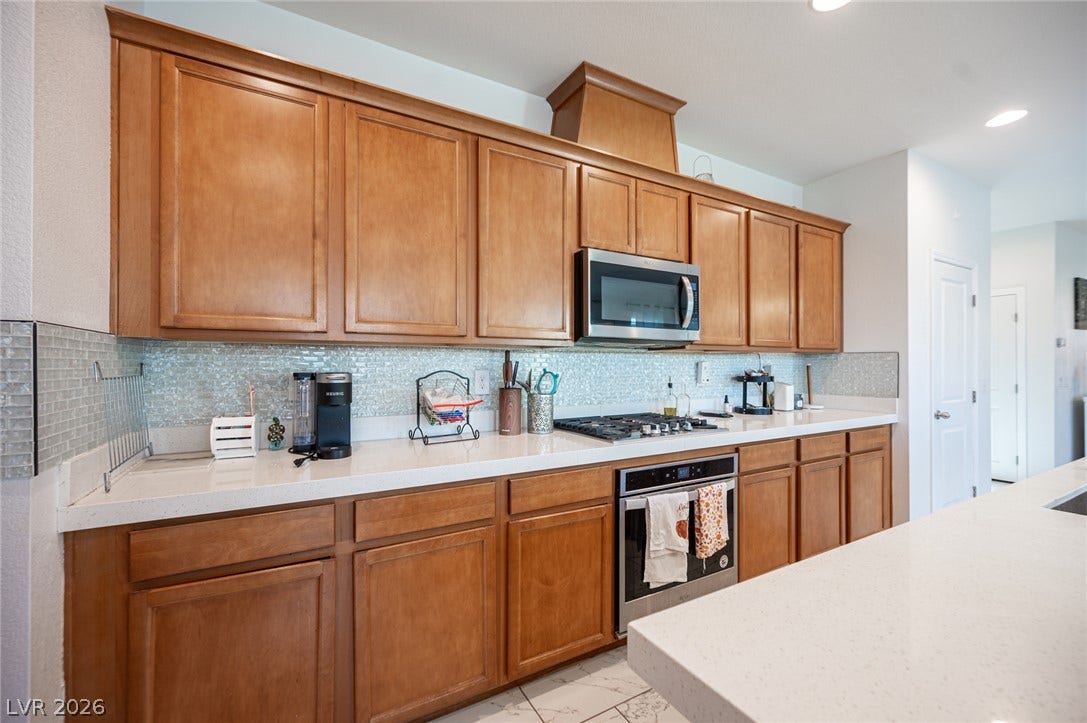 Ample wooden cabinetry and solid countertops anchor this functional kitchen layout.