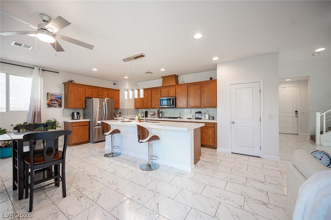 Polished tile flooring and custom cabinetry anchor this bright, open kitchen space.