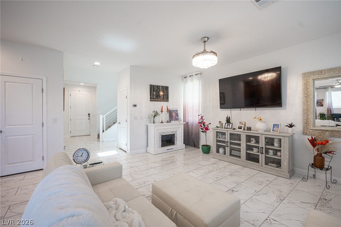 Polished tile flooring and an elegant fireplace define this airy living space.