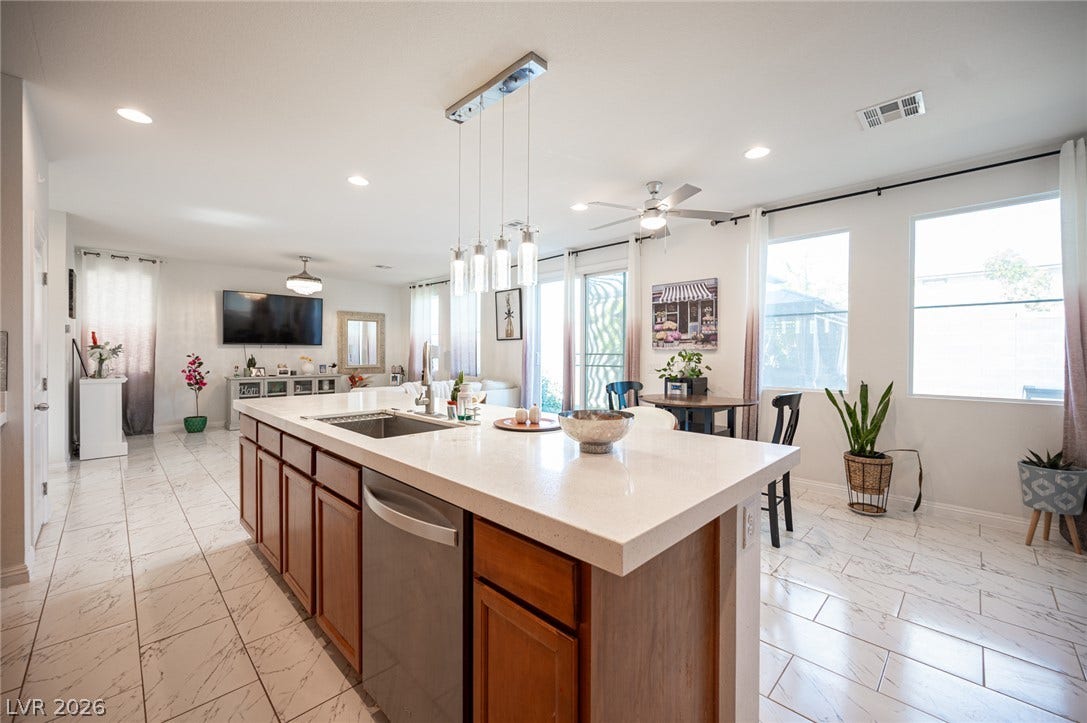 Gleaming tile floors and stone countertops define this airy open-concept living area.
