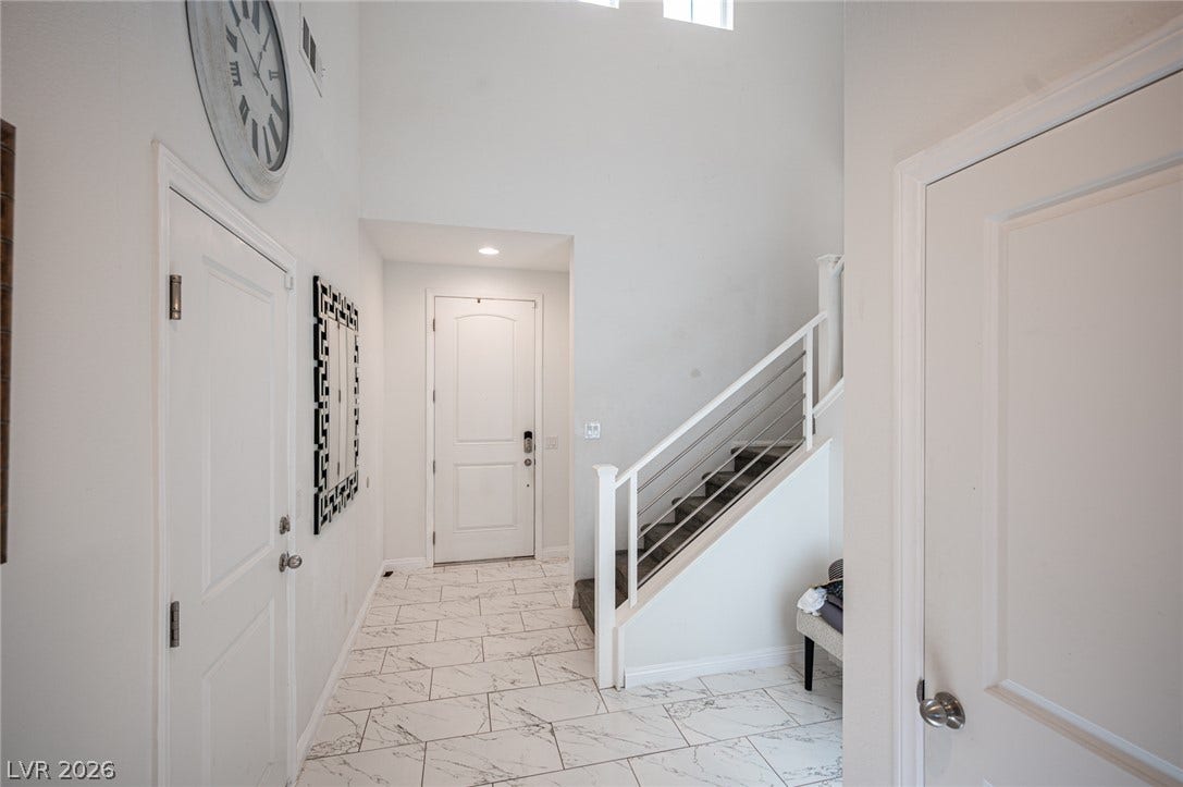 Gleaming tile floors welcome visitors into a soaring entryway featuring clean lines and architectural depth.