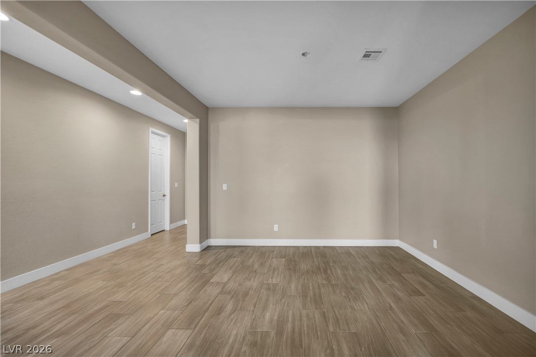 7128 Port Stephens Street, North Las Vegas, NV 89084 A versatile open area showcases wood-look tile flooring paired with neutral-toned walls.