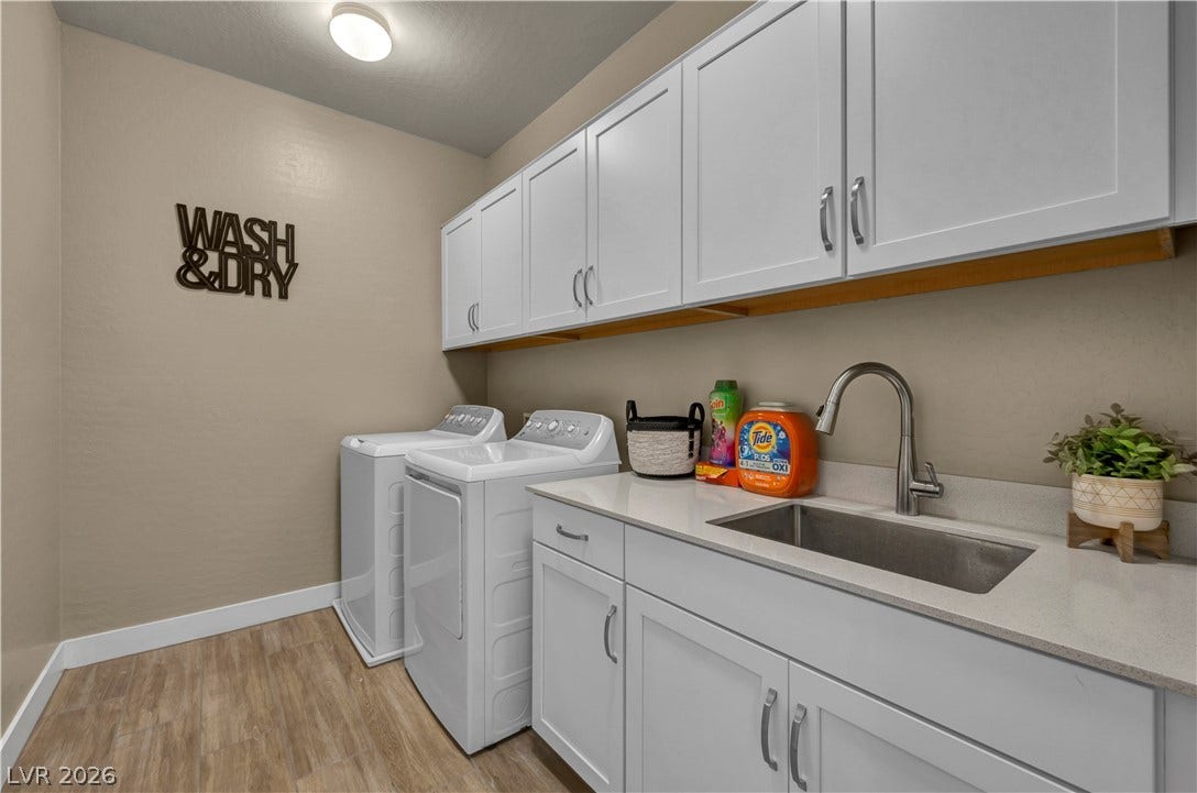 7128 Port Stephens Street, North Las Vegas, NV 89084 Ample white cabinetry and a deep utility sink elevate this dedicated laundry room.