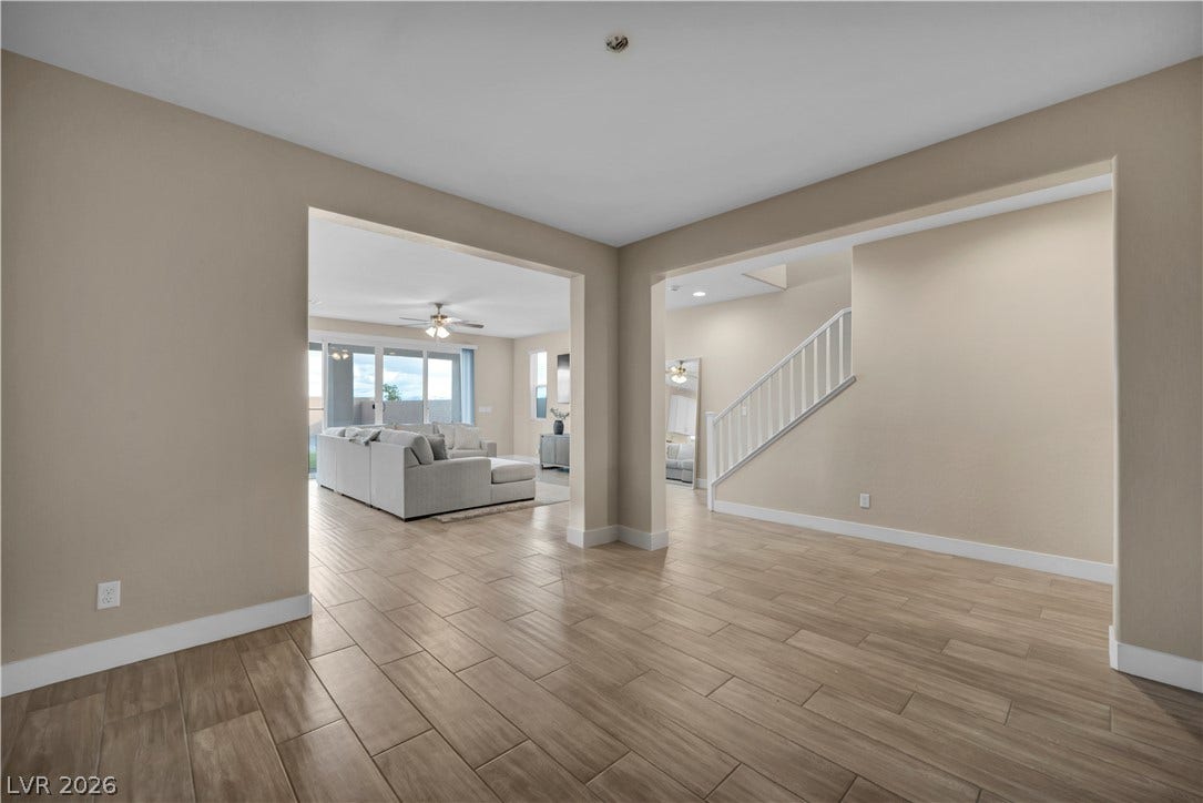 7128 Port Stephens Street, North Las Vegas, NV 89084 Gleaming wood-look tile floors and wide arched openings connect the versatile living spaces.