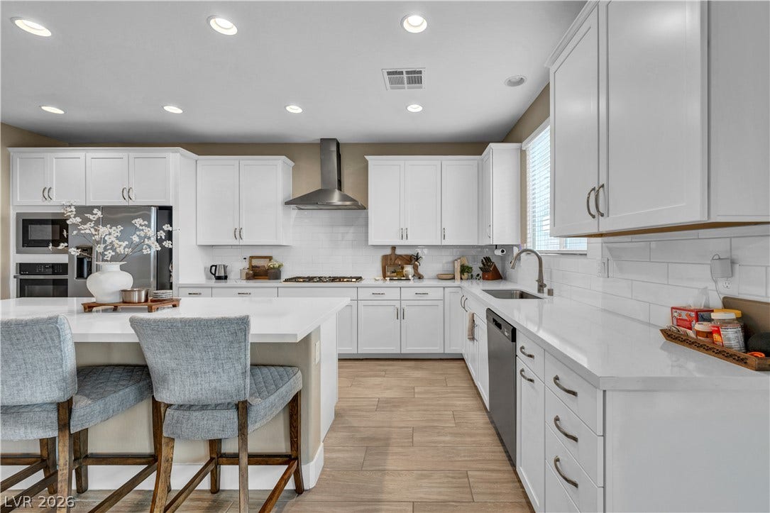 7128 Port Stephens Street, North Las Vegas, NV 89084 Gleaming stone countertops and recessed lighting elevate this modern, well-appointed kitchen workspace.