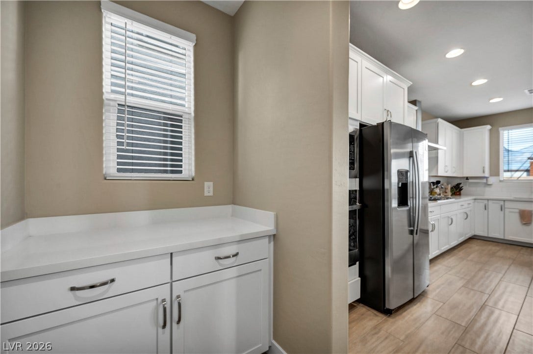 7128 Port Stephens Street, North Las Vegas, NV 89084 Gleaming stone countertops and matching cabinetry flow seamlessly through this open culinary space.