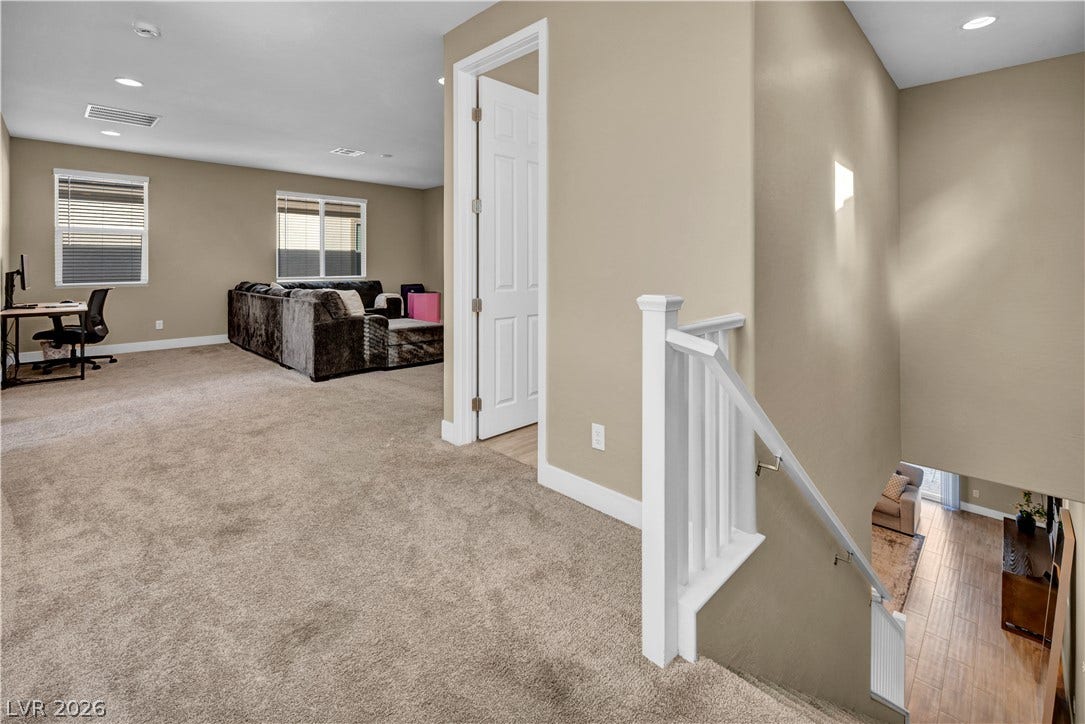 7128 Port Stephens Street, North Las Vegas, NV 89084 A spacious upper-level loft features wall-to-wall carpeting and access to a modern staircase.