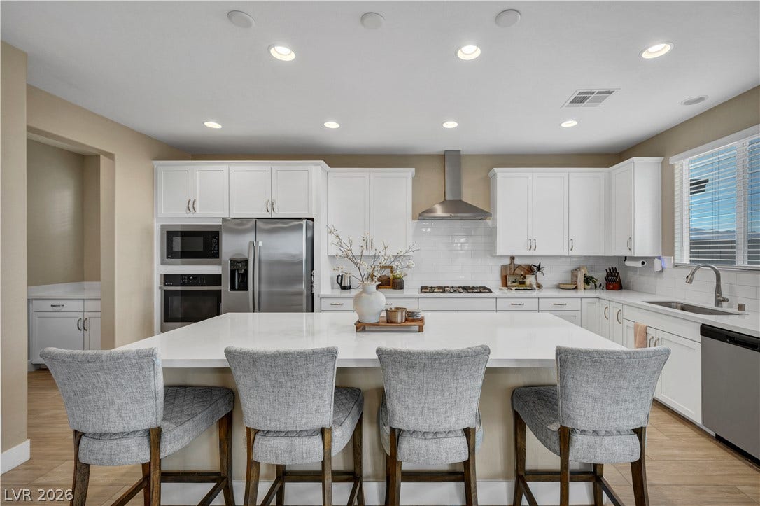 7128 Port Stephens Street, North Las Vegas, NV 89084 Sleek stone countertops and crisp white cabinetry define this modern culinary workspace.