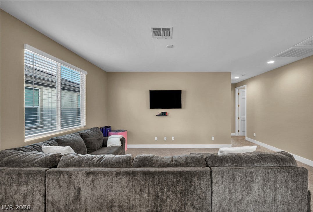 7128 Port Stephens Street, North Las Vegas, NV 89084 Plentiful natural light streams through wide windows onto the comfortable carpeted flooring.