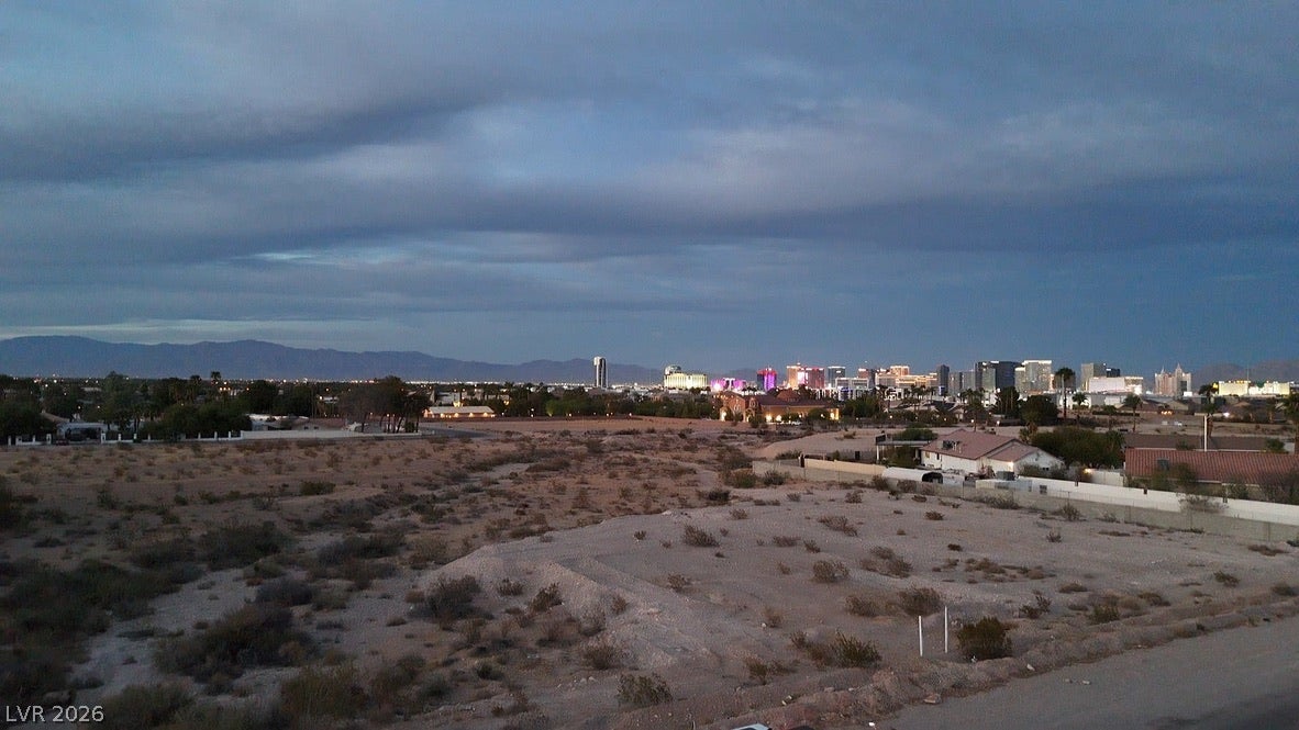 Mohawk, Las Vegas, NV 89118 Distant city lights and rugged mountain silhouettes frame the expansive desert landscape under evening skies.