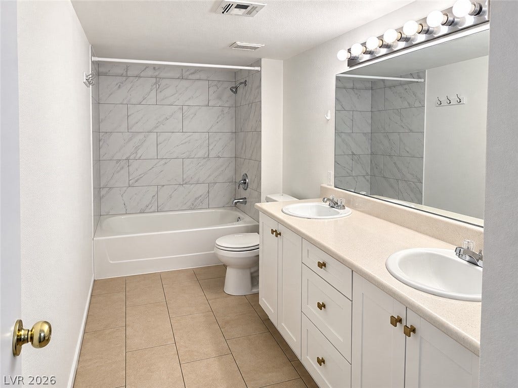 2300 E Silverado Ranch Boulevard, #1077, Las Vegas, NV 89183 Clean tile flooring and a double vanity define this well-appointed bathroom space.