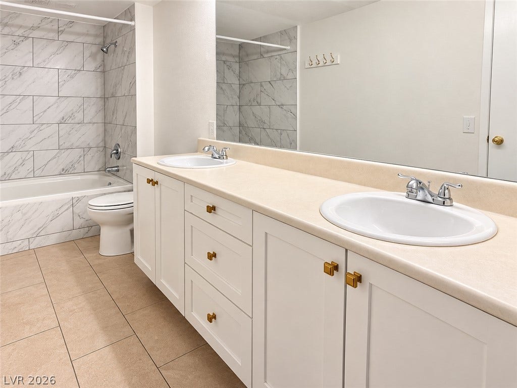 2300 E Silverado Ranch Boulevard, #1077, Las Vegas, NV 89183 Clean tile flooring and a double vanity define this well-appointed bathroom space.