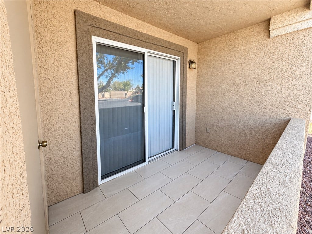 2300 E Silverado Ranch Boulevard, #1077, Las Vegas, NV 89183 Tiled flooring and stucco walls define this private outdoor balcony space.