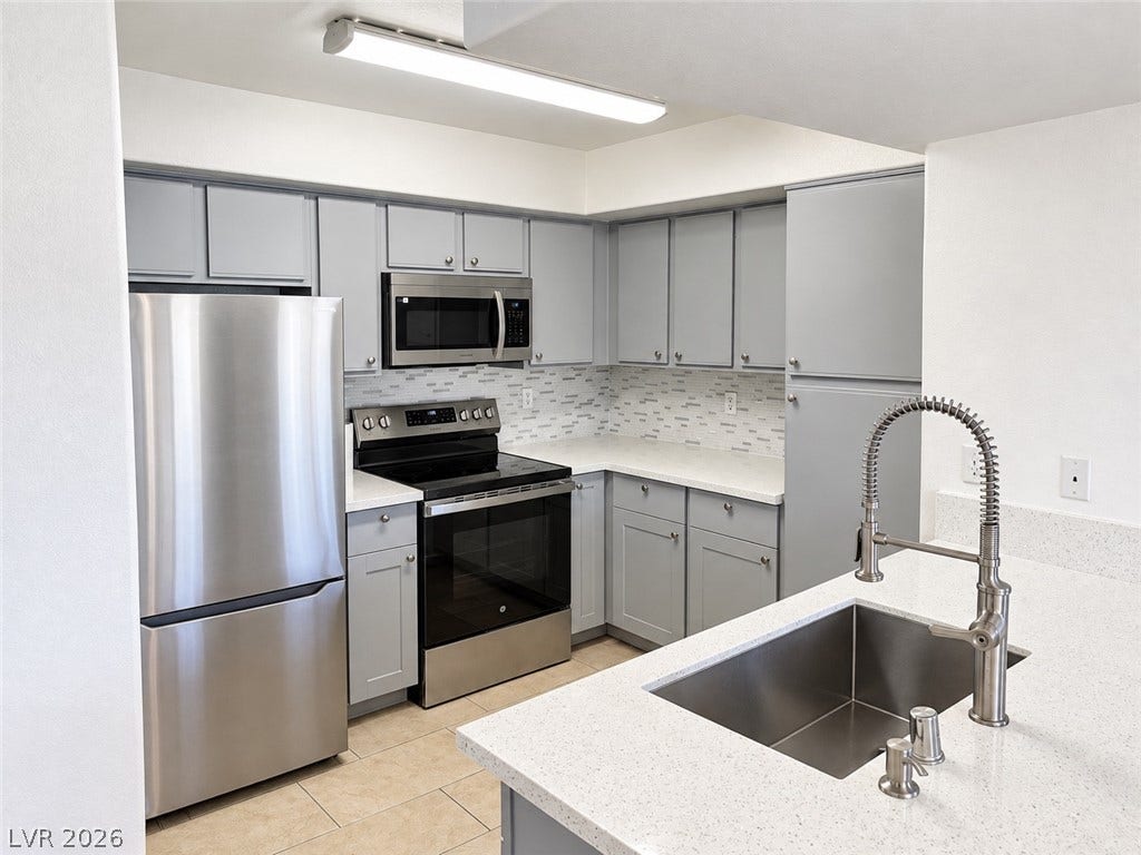 2300 E Silverado Ranch Boulevard, #1077, Las Vegas, NV 89183 Streamlined cabinetry and sleek stainless steel appliances define this modern culinary workspace.