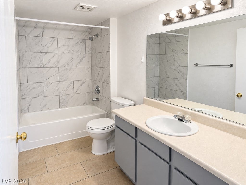 2300 E Silverado Ranch Boulevard, #1077, Las Vegas, NV 89183 A classic tiled shower surround highlights this functional and tidy washroom.