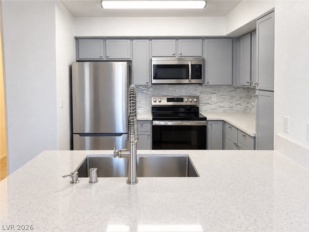 2300 E Silverado Ranch Boulevard, #1077, Las Vegas, NV 89183 Gleaming stone countertops and modern stainless steel appliances define this updated culinary space.