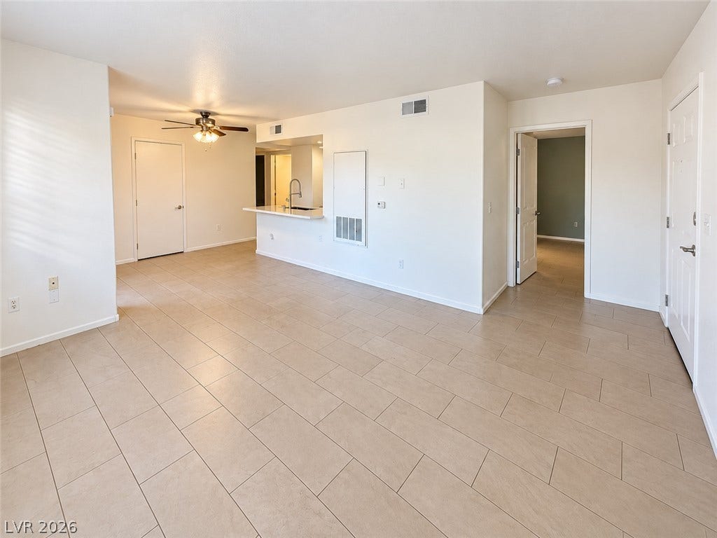 2300 E Silverado Ranch Boulevard, #1077, Las Vegas, NV 89183 Tiled flooring and neutral walls define this versatile open living space flowing toward the kitchen.