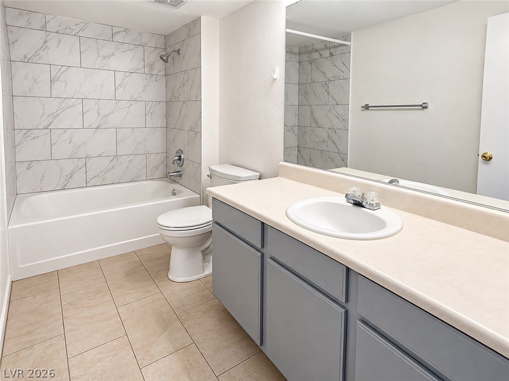 2300 E Silverado Ranch Boulevard, #1077, Las Vegas, NV 89183 Tiled flooring and a modern shower enclosure define this updated bathroom space.