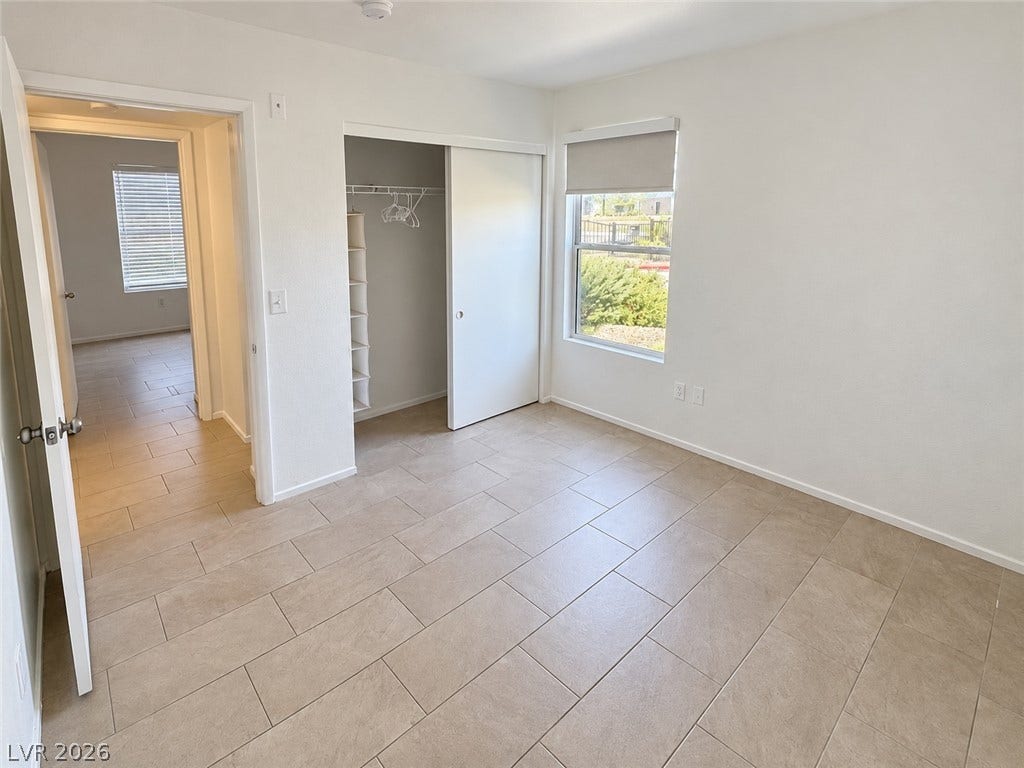 2300 E Silverado Ranch Boulevard, #1077, Las Vegas, NV 89183 Tiled flooring and a sliding door closet define this bright secondary bedroom.