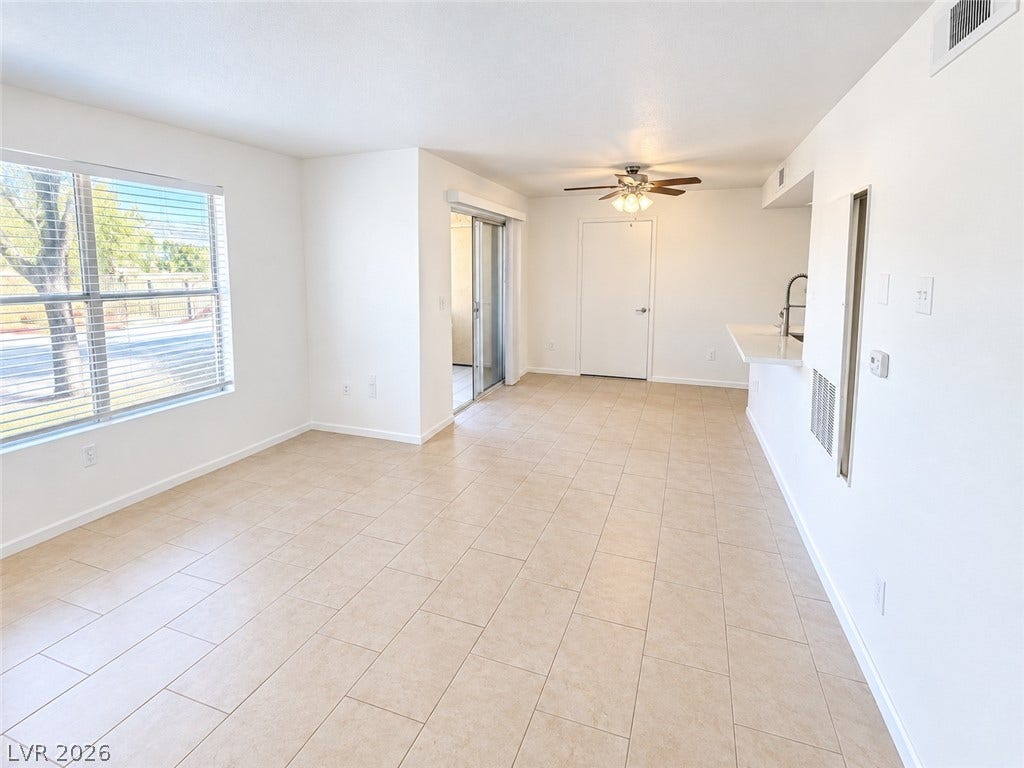 2300 E Silverado Ranch Boulevard, #1077, Las Vegas, NV 89183 An open layout flows seamlessly across easy-care tile flooring in this versatile living space.