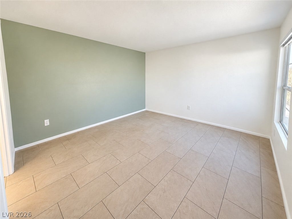 2300 E Silverado Ranch Boulevard, #1077, Las Vegas, NV 89183 Tiled flooring and large windows define this versatile room.