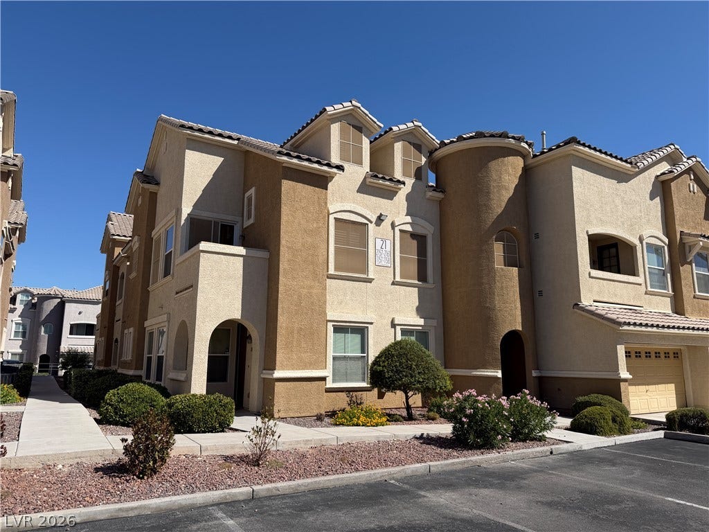 8777 W Maule Avenue, #1158, Las Vegas, NV 89148 Multi-level Mediterranean-inspired architecture featuring warm stucco finishes under a clear blue sky.