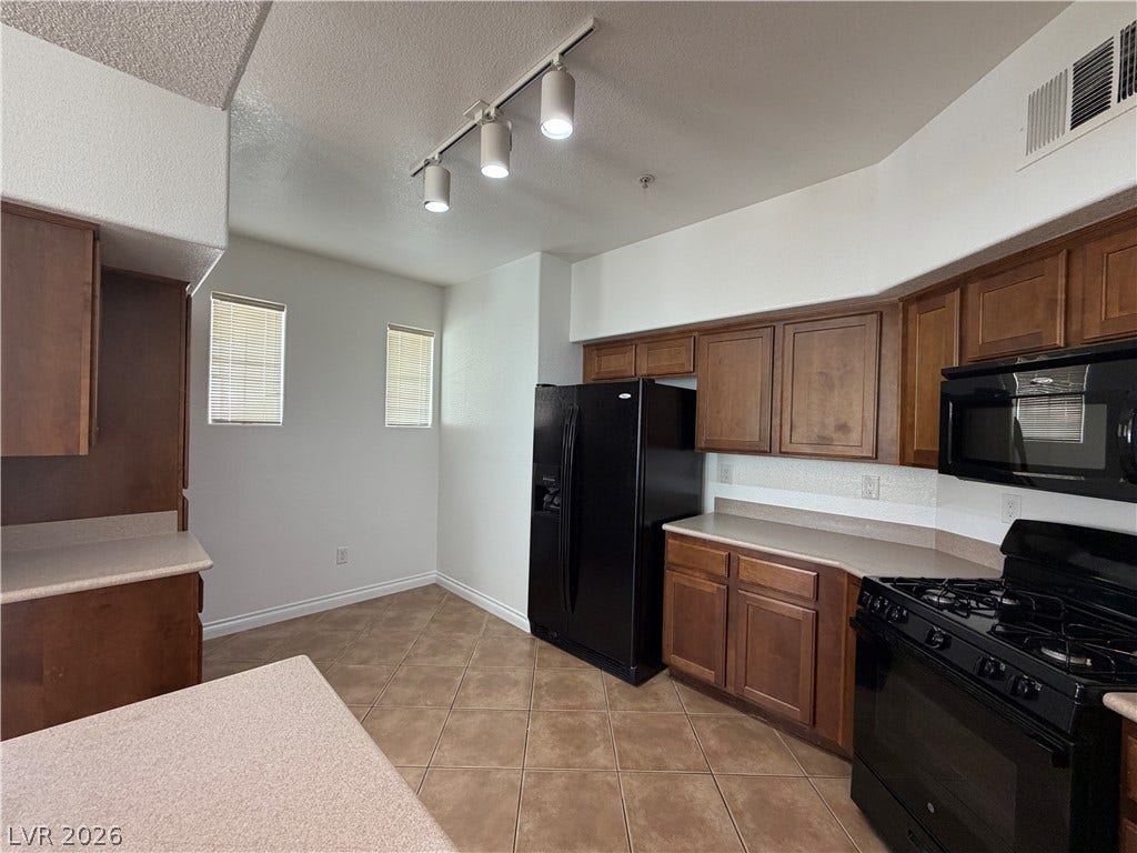8777 W Maule Avenue, #1158, Las Vegas, NV 89148 Rich wood cabinetry contrasts beautifully with ceramic tile flooring in this functional culinary space.