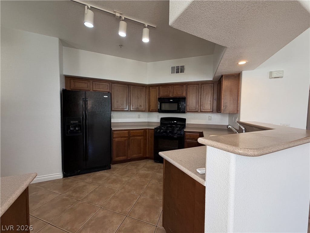 8777 W Maule Avenue, #1158, Las Vegas, NV 89148 Ample counter space and classic cabinetry define this functional kitchen layout with tile flooring.