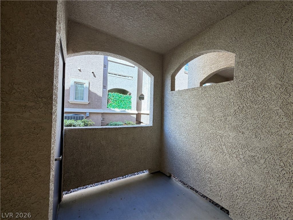 8777 W Maule Avenue, #1158, Las Vegas, NV 89148 Arched architectural openings frame the surrounding neighborhood views from this private concrete patio.