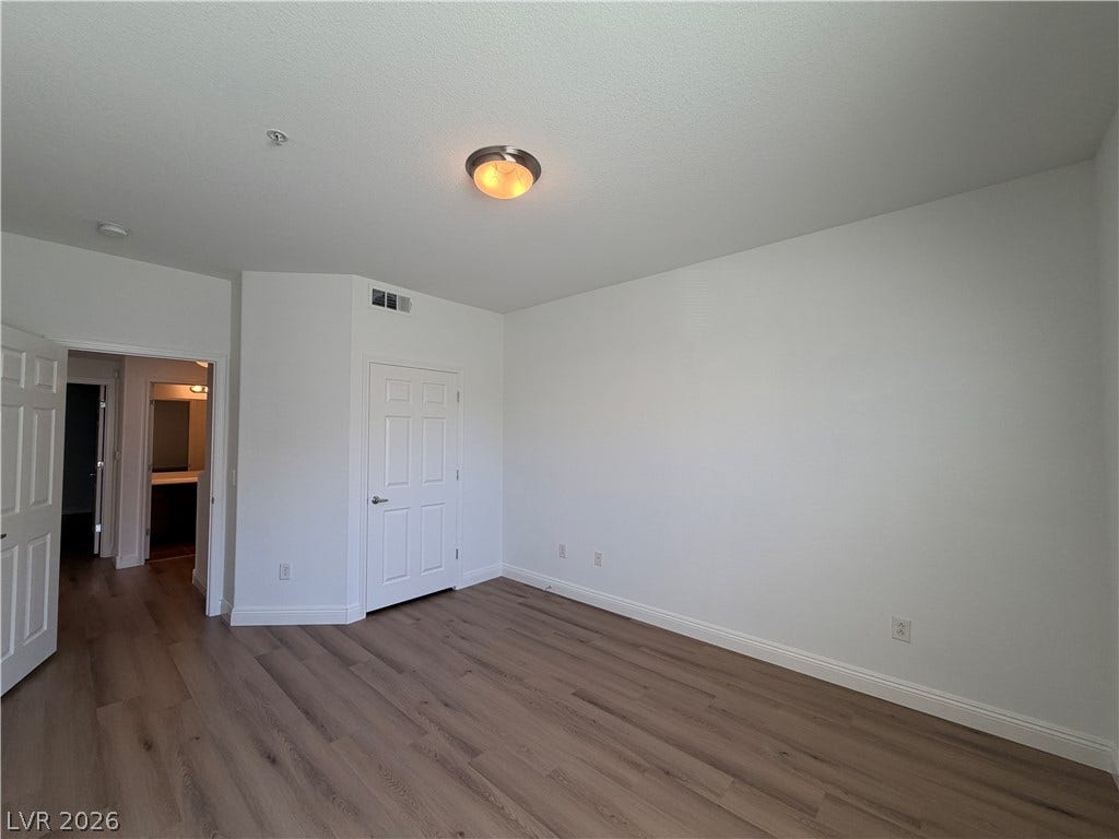 8777 W Maule Avenue, #1158, Las Vegas, NV 89148 Smooth wood-style flooring and high ceilings define this versatile bedroom space.