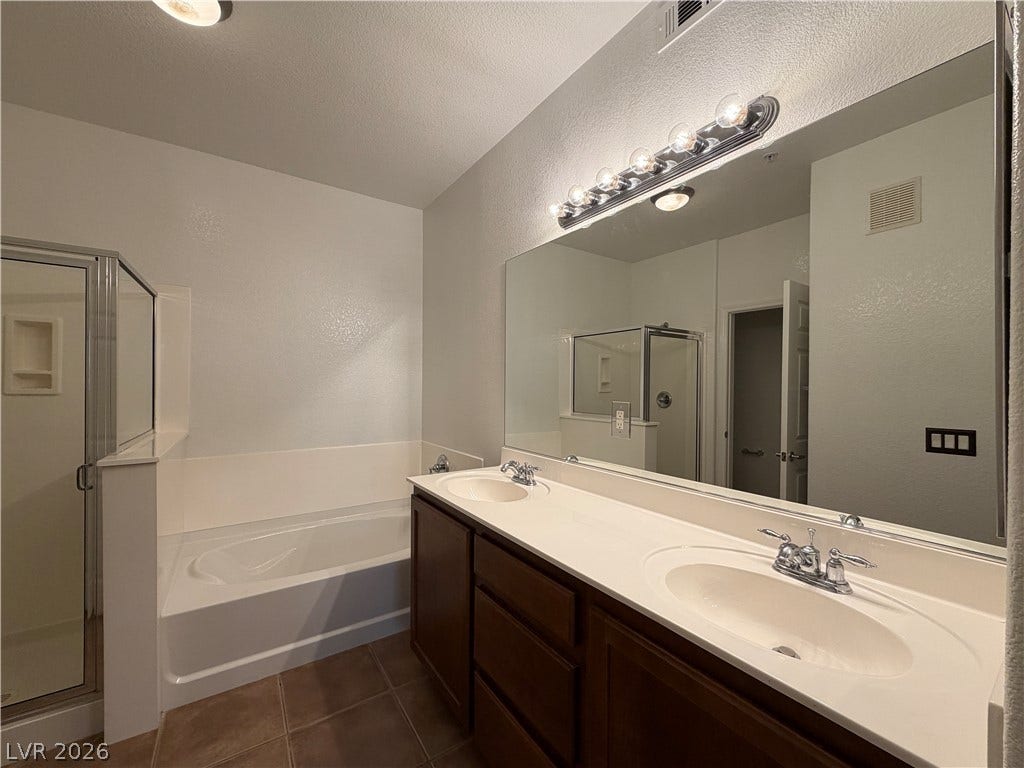 8777 W Maule Avenue, #1158, Las Vegas, NV 89148 An expansive vanity mirror sits above dual sinks alongside a deep soaking tub.