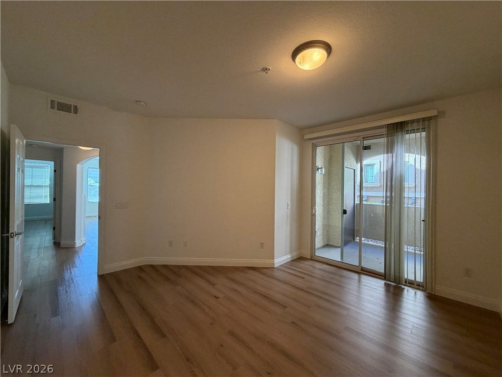8777 W Maule Avenue, #1158, Las Vegas, NV 89148 Warm wood flooring and sliding glass doors create an inviting transition to the private balcony.