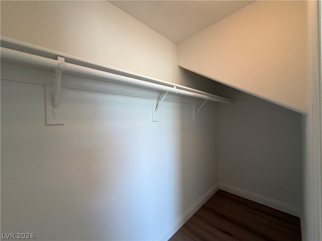 8777 W Maule Avenue, #1158, Las Vegas, NV 89148 An organized closet provides practical storage options with built-in hanging rods and wood flooring.