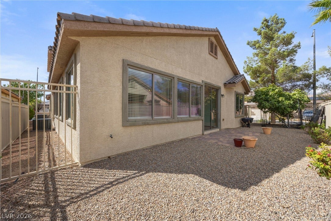 5824 Pleasant Palms Street, North Las Vegas, NV 89081 Gravel landscaping surrounds this stucco home featuring a tiled roof and a gated backyard.