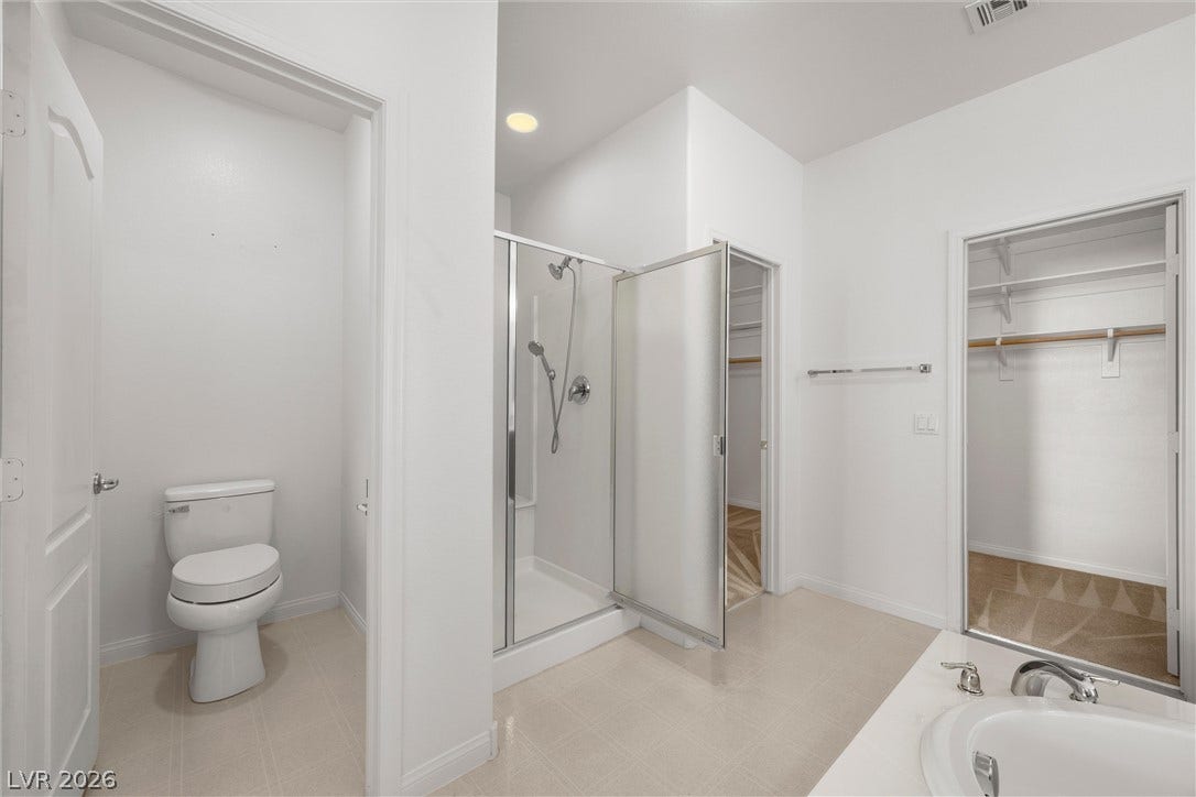 5824 Pleasant Palms Street, North Las Vegas, NV 89081 A glass-enclosed shower, built-in soaking tub, and tile floors complete this functional layout.