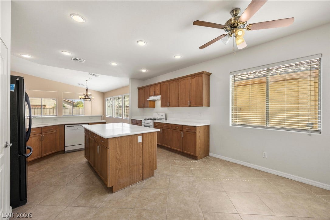 5824 Pleasant Palms Street, North Las Vegas, NV 89081 Tiled flooring and wood cabinetry define this open kitchen space featuring a central island.