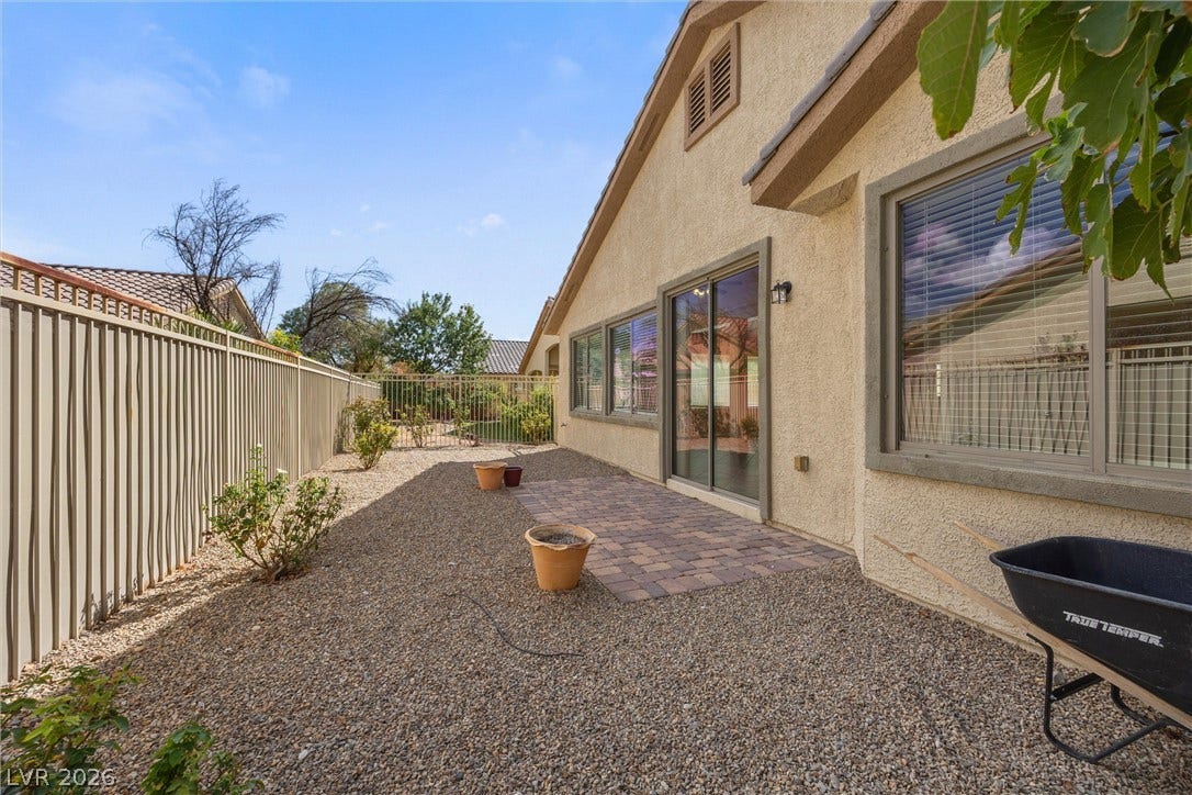 5824 Pleasant Palms Street, North Las Vegas, NV 89081 A gravel-lined side yard features a small paver patio alongside stucco exterior walls.