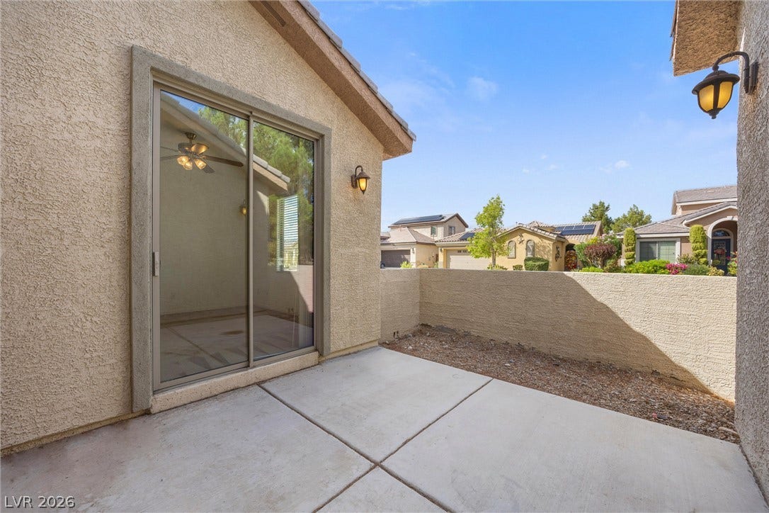 5824 Pleasant Palms Street, North Las Vegas, NV 89081 Courtyard outside the Den. Concrete slabs form a private courtyard enclosed by low stucco walls under open skies.