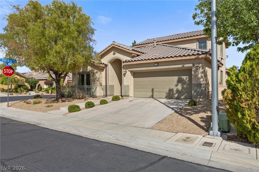 5824 Pleasant Palms Street, North Las Vegas, NV 89081 A spacious driveway leads to the integrated garage of this stucco home with a tile roof.