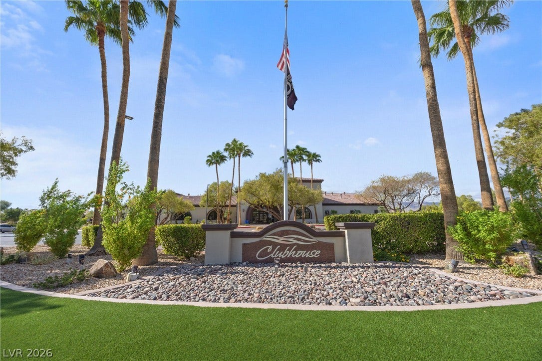 5824 Pleasant Palms Street, North Las Vegas, NV 89081 Manicured landscaping surrounds the entry sign to the community clubhouse under a blue sky.