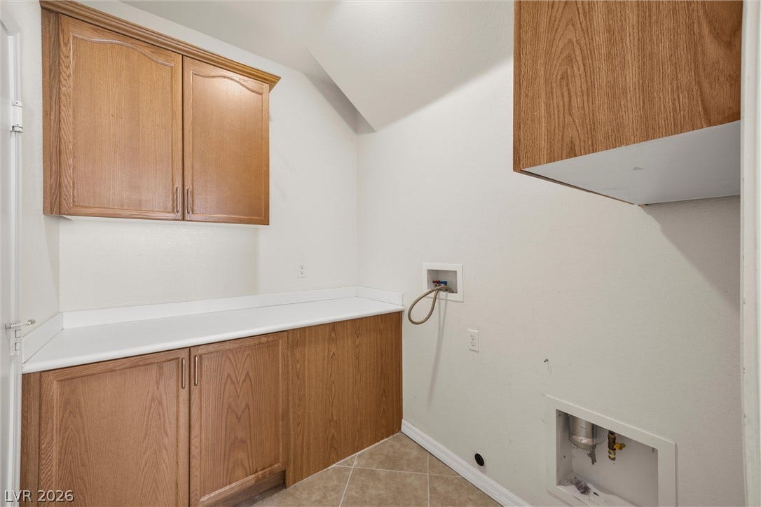 5824 Pleasant Palms Street, North Las Vegas, NV 89081 Ample built-in oak cabinetry and solid counters elevate this functional utility space.